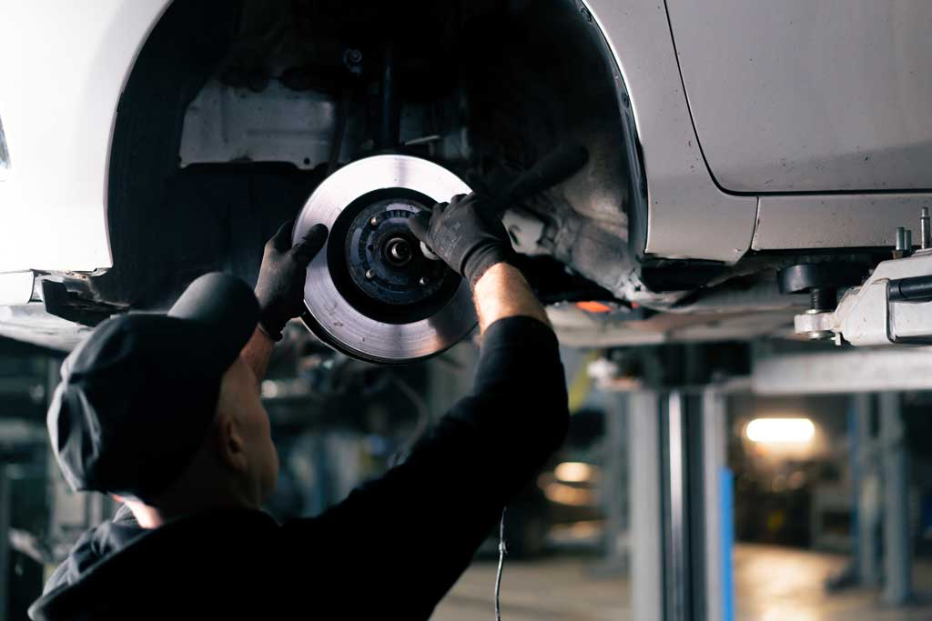  Technician installing a new brake rotor in a car to ensure durability