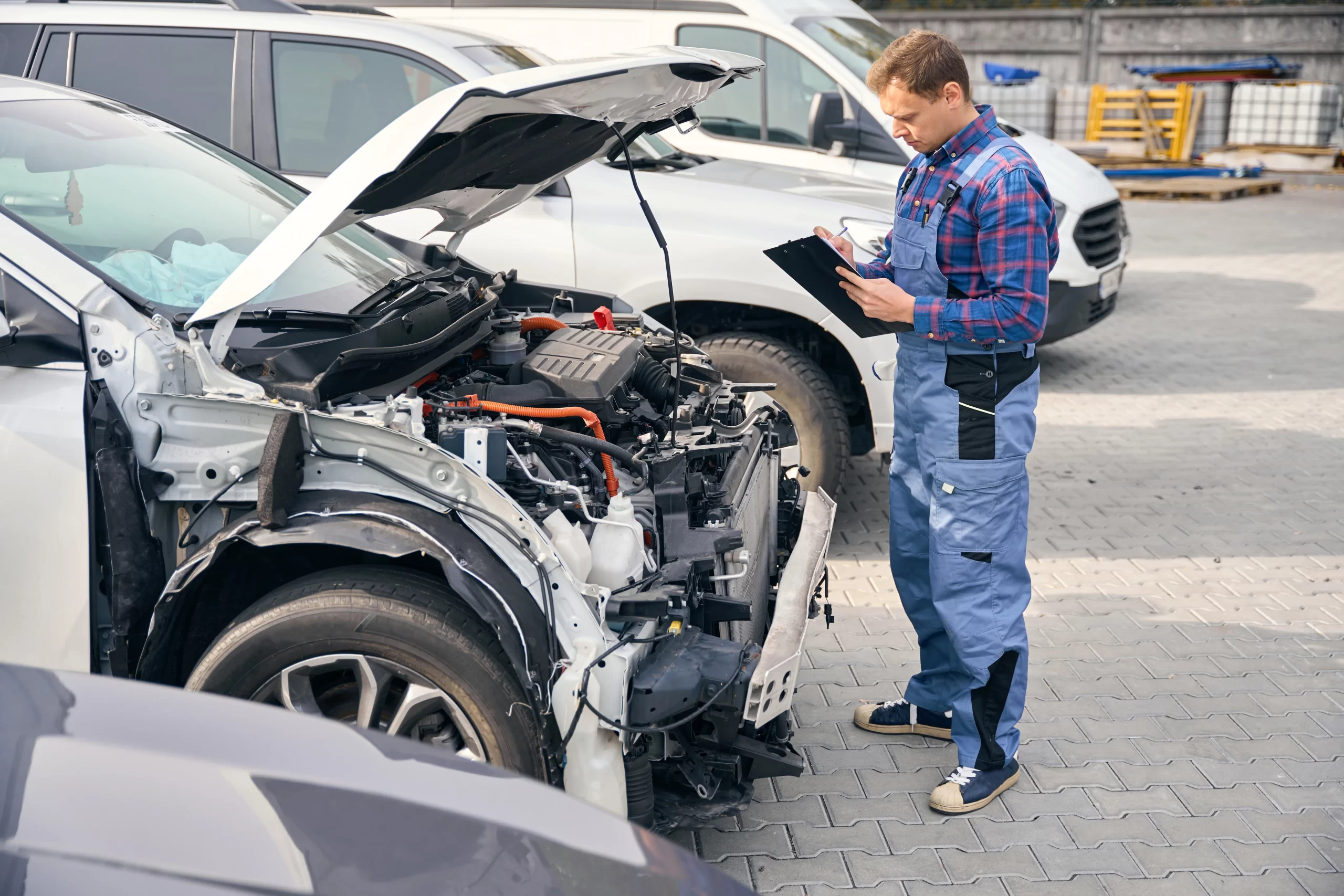 A certified technician inspecting a damaged vehicle for an accurate insurance claim assessment